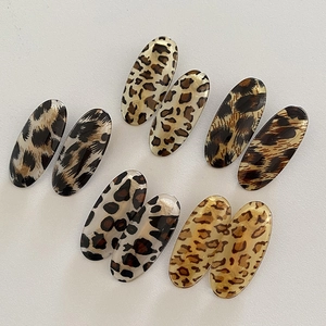 Five pairs of oval leopard print hair clips in various vintage resin patterns