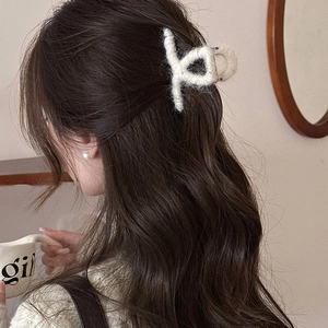 Dettaglio della molletta per capelli in peluche bianco crema per capelli lunghi mossi