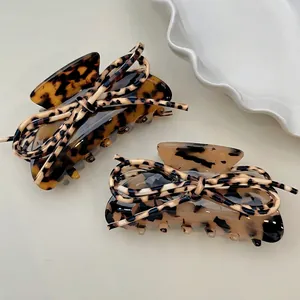 Pair of leopard print shark hair clips with ribbon bows in dark and light brown tones