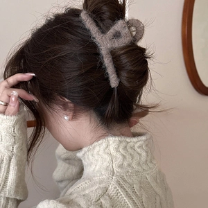 Dettaglio di una grande molletta per capelli in peluche marrone per uno stile autunnale