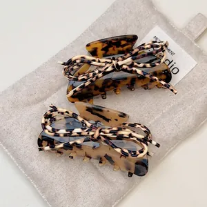 Vintage leopard print hair claw clip set with bow detail on grey linen background