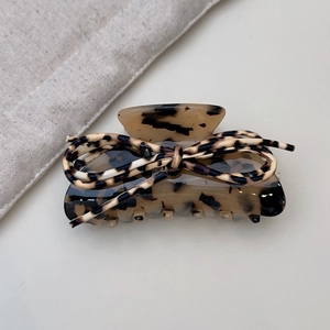Close-up of leopard print bow hair claw clip with elegant tortoiseshell pattern