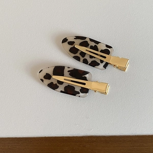 Close-up of leopard print acetate hair clips with golden metal duckbill clips