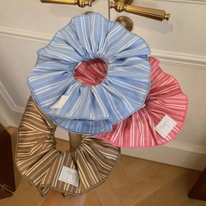 Three striped oversized scrunchies in blue, pink, and brown with chic bow labels