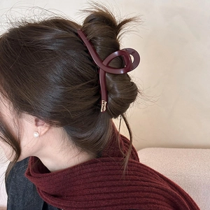 Detail of dark red matte hair claw clip on model featuring golden Barrette La France text