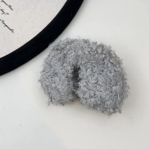 Detailed view of the soft grey plush hair tie featuring a fluffy faux fur texture