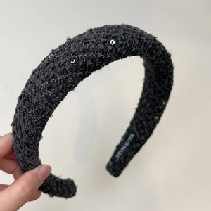 Detail of black tweed headband with silver sequins showing handmade inner label