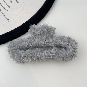 Close-up detail of grey plush faux fur hair claw clip for elegant women styling