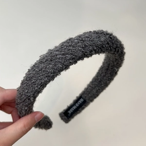 Macro detail of charcoal grey tweed texture headband with silver sequins and hand made label