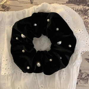 Elegant black velvet scrunchie with white pearls on a lace background for women