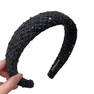 Elegant black tweed headband with silver sequins and handmade label on white background