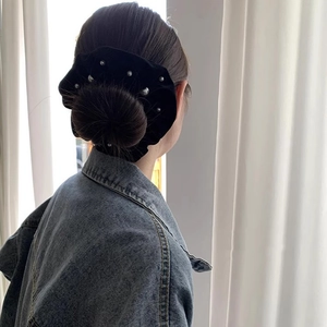 Elegant black velvet scrunchie with white pearls on high bun hairstyle for women