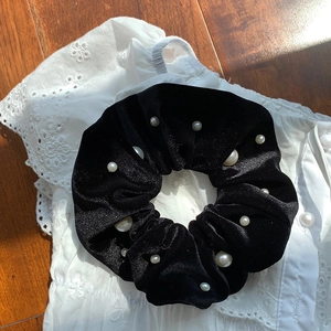 Detail of premium black velvet scrunchie with white imitation pearls on lace