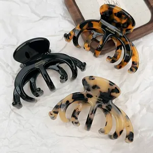 Close-up of tortoise shell and marble acetate claw clips with gold handmade logo