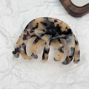 Detailed macro view of the handmade acetate hair claw clip with golden French engraving