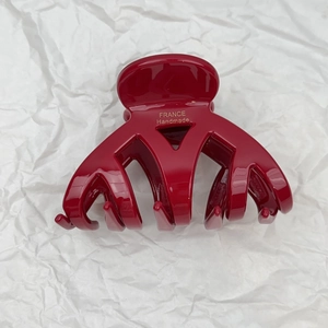 Detail showing red cellulose acetate hair claw with golden France Handmade logo