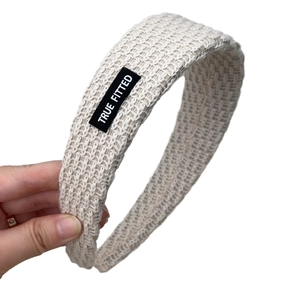 Beige chunky knit headband for women featuring a woven brand label for autumn winter style