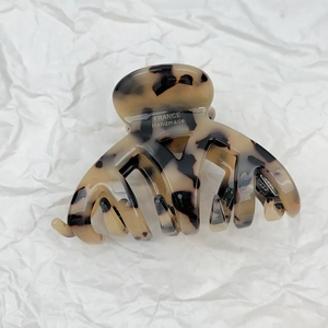 Close-up of tortoise shell pattern acetate hair claw clip with gold France Handmade logo