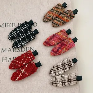 Französischer Tweed-Haarspangen-Set in fünf Farben auf strukturiertem Hintergrund