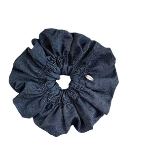 Chouchou français en jean bleu foncé avec coutures et étiquette métallique
