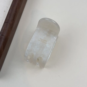 Detail der perlweißen Haarklammer aus Acetat mit goldenem Barrette La France Schriftzug