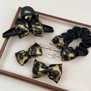 Leopard print hair accessory set with claw clip and scrunchie in black and gold