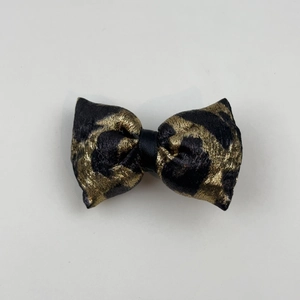 Detailed view of the leopard print jacquard bow hair clip with gold and black metallic finish