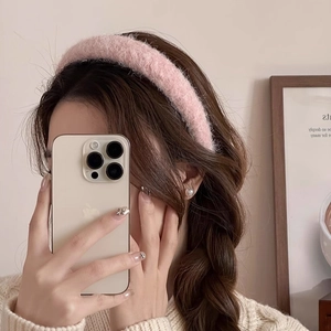 Gros plan d'un serre-tête en peluche rose porté pour un look automnal élégant et chic