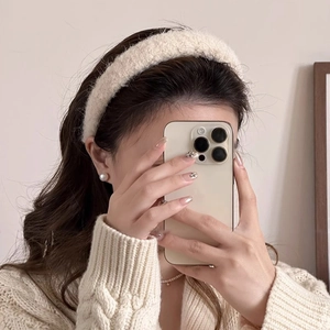 Gros plan détaillé d'un serre-tête en peluche blanche assorti à un cardigan en maille