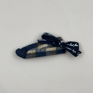 Detail of vintage blue plaid hair clip with a ribbon bow and elegant script lettering