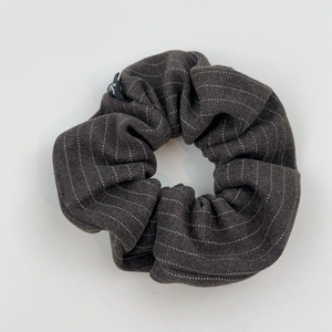 Détail d'un chouchou gris foncé à rayures montrant la texture et la petite étiquette