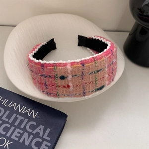 Detailed close-up of pink tweed headband with pearl trim and multicolor fiber textures