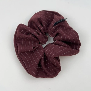 Vue détaillée du tissu rayé rouge foncé et de l'étiquette noire du chouchou