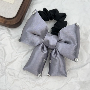 Macro shot of grey silk scrunchie with sparkling rhinestones and black elastic band