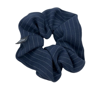Chouchou en tissu bleu marine à rayures avec plis souples et étiquette de marque discrète