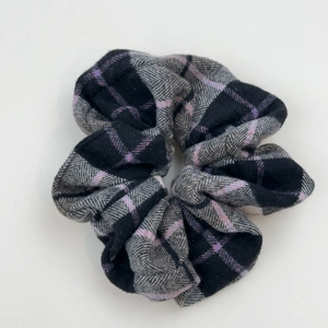 Detailed close-up of a plaid hair scrunchie with grey and purple wool texture fabric