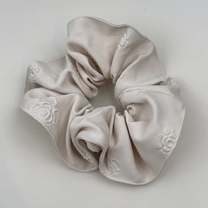 Detail of ivory scrunchie with 3D floral texture and soft knitted fabric finish