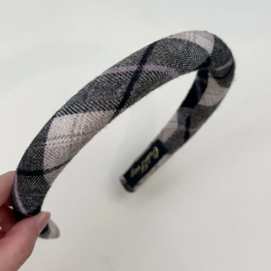 Detail of grey plaid padded headband with purple lines and non-slip inner lining