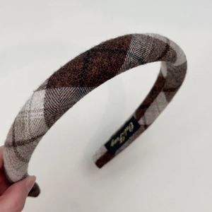 Close-up of retro brown plaid tweed headband with sponge padding and elegant texture