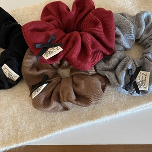 Detail of four-color knitted hair scrunchies with chic ribbon bows and handmade cloth labels