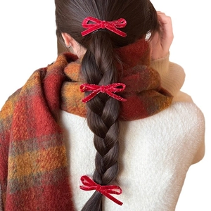 Trois barrettes nœuds en velours rouge sur une tresse pour un style balletcore hivernal