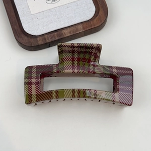 Close-up of a large red and green plaid shark hair claw clip with a glossy finish
