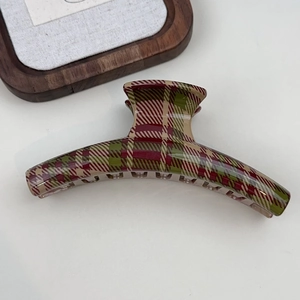 Close-up of a large red and green plaid shark hair clip with glossy resin finish