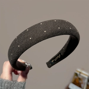 Detailed close-up of thick black sponge headband with white polka dot sequin embellishments