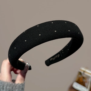 Detail of black padded headband with silver rhinestones and premium knit texture