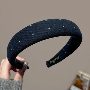 Close-up of black sponge headband with silver dots and soft knit texture finish