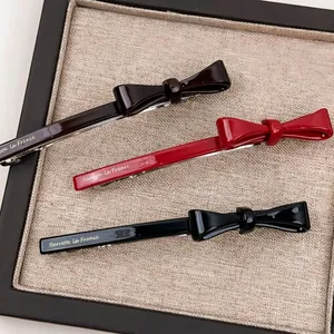 French vintage style acetate bow hair clips set in red and black with gold lettering