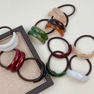 Colorful resin arc hair ties with high elasticity and gold lettering on wooden tray
