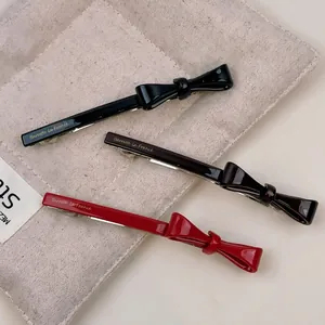 Three-piece acetate bow hair clip set in black, dark brown, and red colors