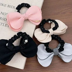 Lot de quatre chouchous nœuds en laine avec perles en rose, beige, noir et bleu clair